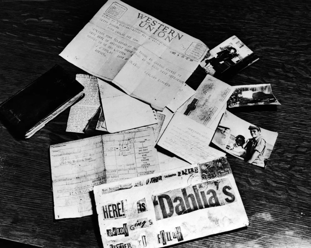 A collection of old papers and photographs spread out on a wooden surface, including a Western Union telegram, various letters, and images of people.